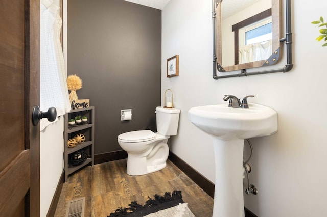 bathroom with wood-type flooring, sink, and toilet