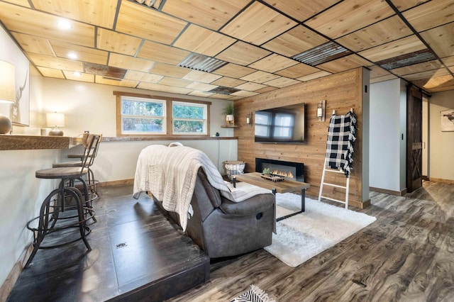 living room featuring dark hardwood / wood-style flooring and wooden walls