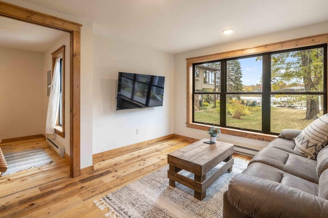 living room featuring a baseboard heating unit and light hardwood / wood-style floors