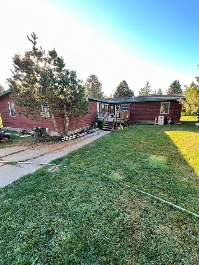 view of front of property featuring a wooden deck and a front yard