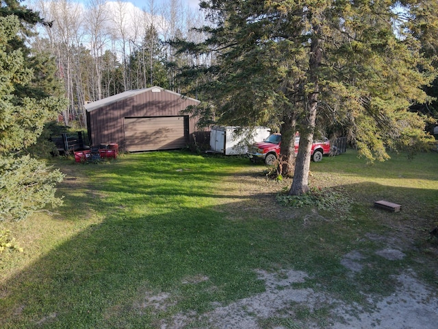 view of yard with a garage and an outbuilding