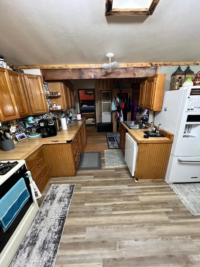 kitchen with light hardwood / wood-style flooring, sink, and white appliances