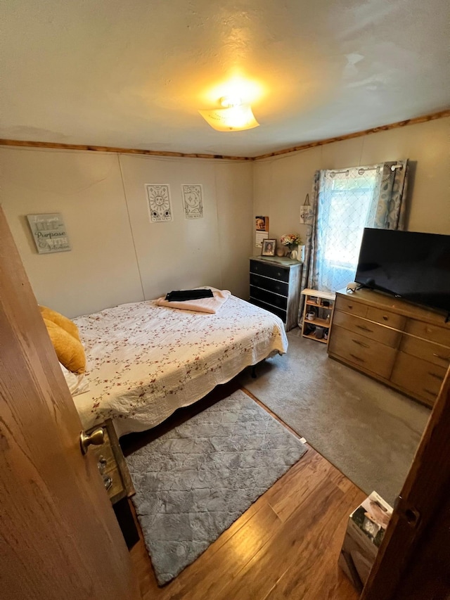 bedroom featuring ornamental molding and hardwood / wood-style floors