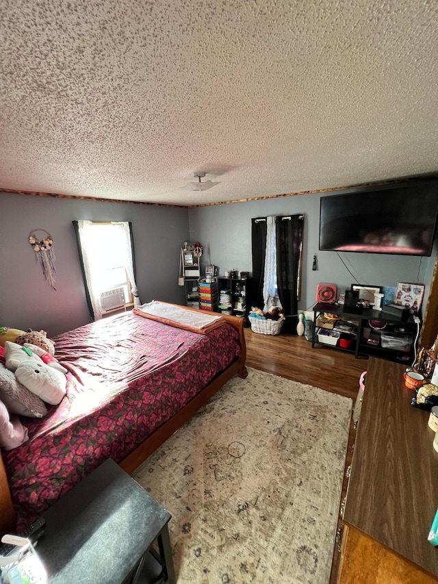 bedroom featuring hardwood / wood-style flooring and a textured ceiling