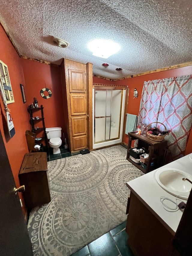 bedroom featuring dark tile patterned floors, sink, and a textured ceiling