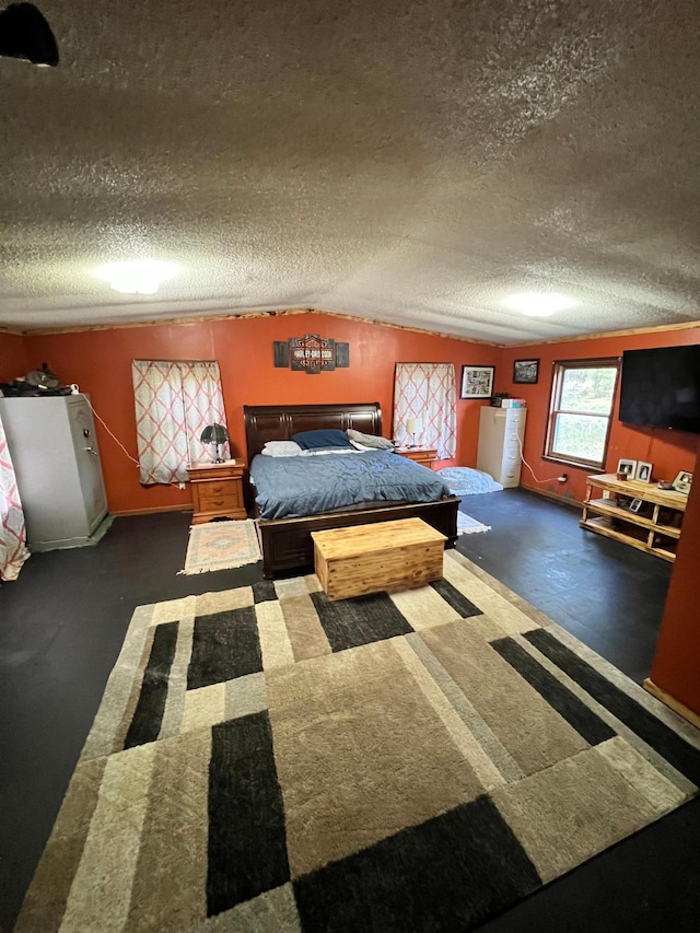 bedroom featuring lofted ceiling, dark carpet, and a textured ceiling