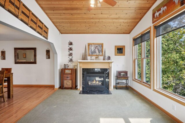 unfurnished living room featuring lofted ceiling, wood-type flooring, wooden ceiling, and a healthy amount of sunlight