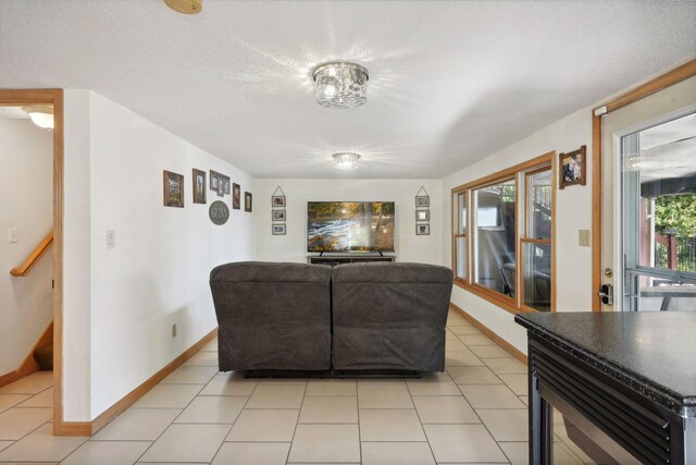 living room with a textured ceiling and light tile patterned floors