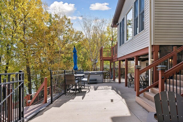 wooden terrace with a patio area and a hot tub