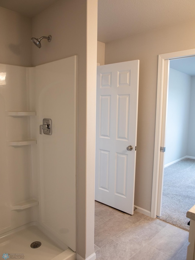 bathroom with a shower and tile patterned flooring