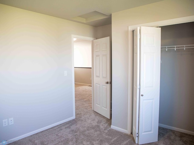 unfurnished bedroom with light carpet and a closet