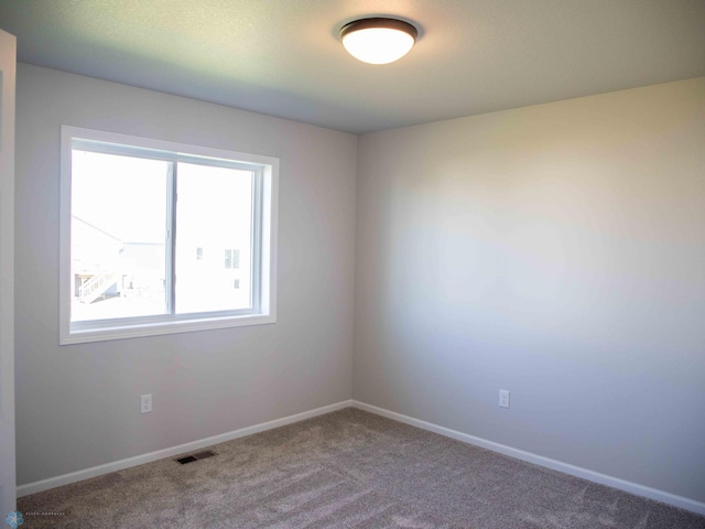 carpeted spare room featuring plenty of natural light