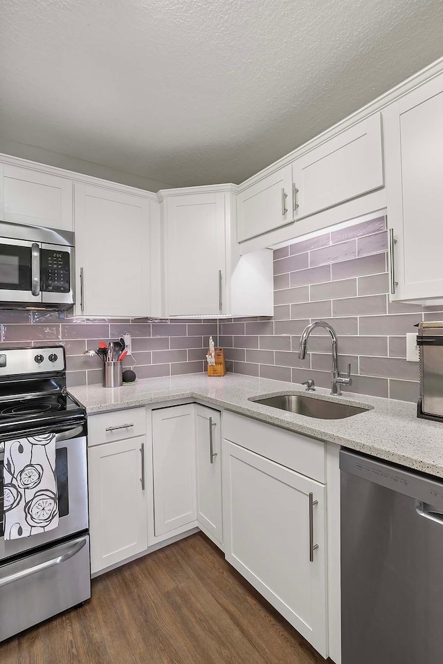 kitchen featuring appliances with stainless steel finishes, sink, and white cabinets