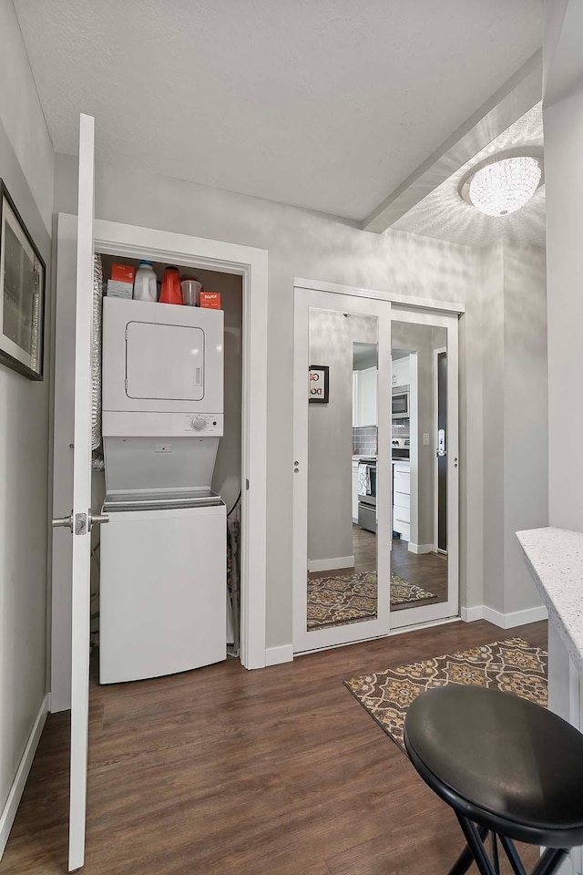 washroom with stacked washer / drying machine and dark hardwood / wood-style floors