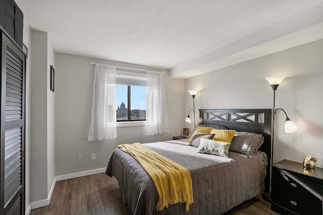 bedroom featuring dark wood-type flooring and a textured ceiling