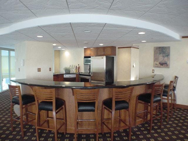 kitchen featuring appliances with stainless steel finishes, a breakfast bar, and carpet floors