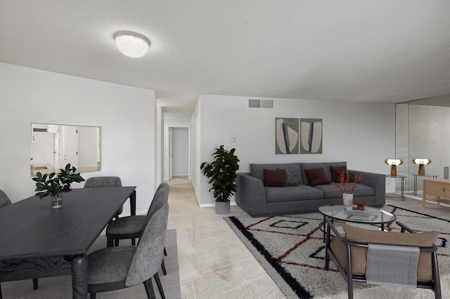 carpeted living room featuring a textured ceiling