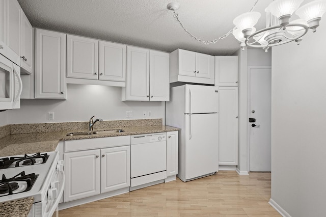 kitchen featuring white cabinetry, a textured ceiling, white appliances, and sink