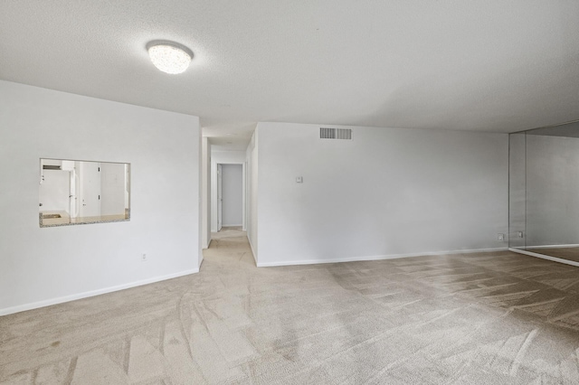 carpeted spare room with a textured ceiling