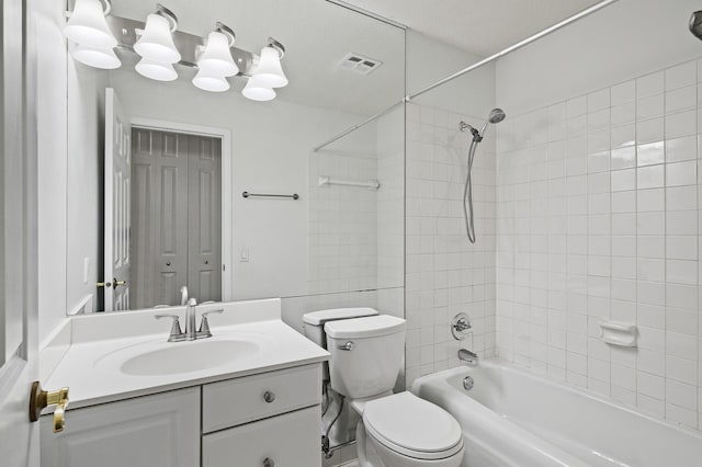 full bathroom with vanity, toilet, a textured ceiling, and tiled shower / bath