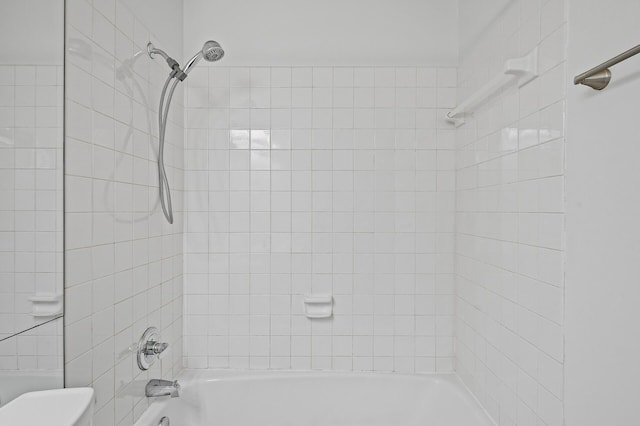 bathroom featuring toilet and tiled shower / bath combo