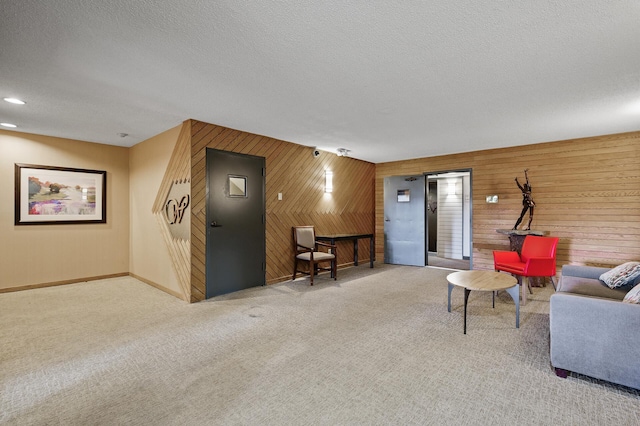 carpeted living room featuring wooden walls and a textured ceiling