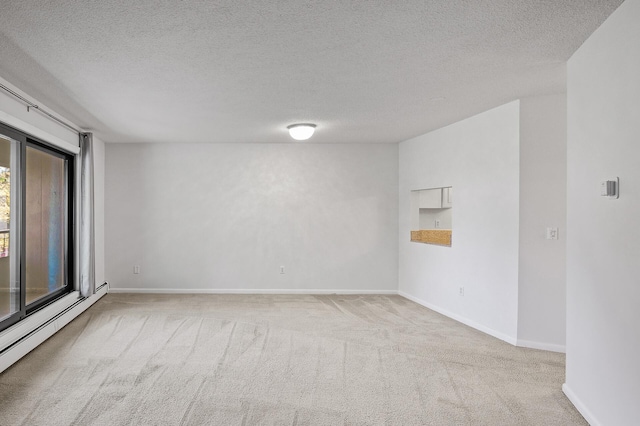 unfurnished room featuring baseboard heating, a textured ceiling, and light colored carpet