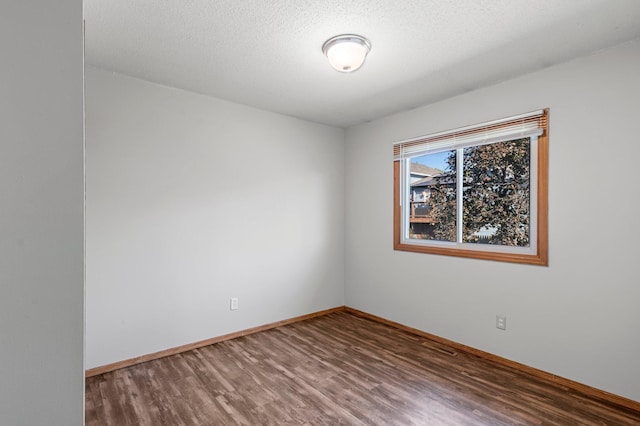 empty room featuring hardwood / wood-style floors and a textured ceiling