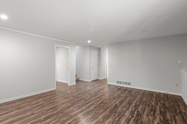 spare room with dark wood-type flooring and a textured ceiling