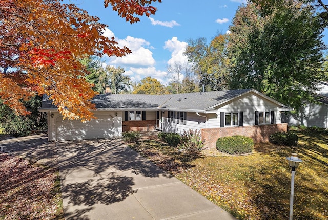 single story home with a porch, a front yard, and a garage