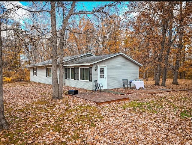 rear view of house featuring a wooden deck