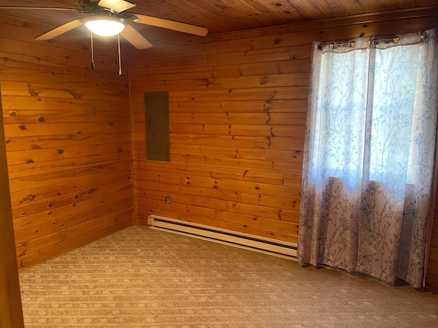 carpeted spare room featuring ceiling fan, wood walls, wooden ceiling, and baseboard heating