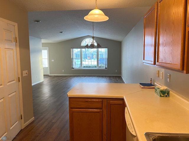 kitchen featuring vaulted ceiling, dark hardwood / wood-style floors, pendant lighting, dishwasher, and a textured ceiling