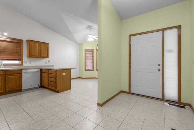 kitchen featuring ceiling fan, kitchen peninsula, white dishwasher, lofted ceiling, and light tile patterned floors