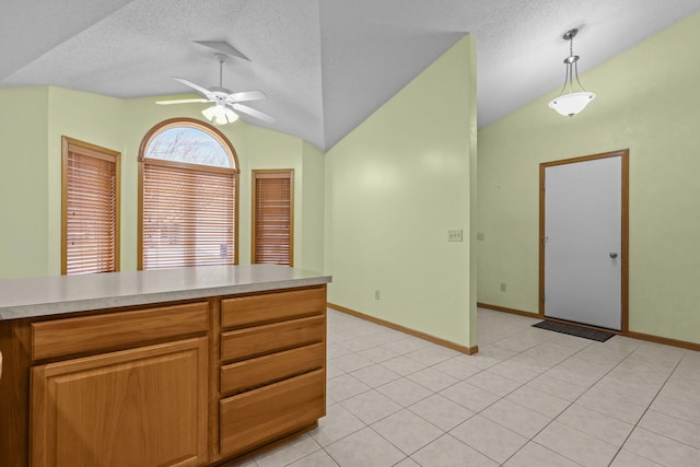 kitchen with a textured ceiling, ceiling fan, hanging light fixtures, and vaulted ceiling