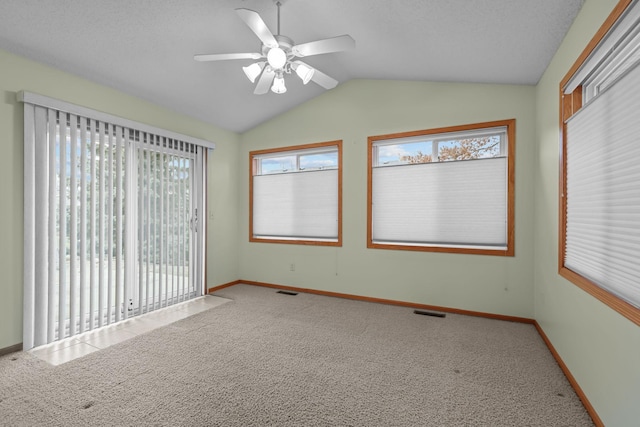 spare room with a textured ceiling, carpet floors, ceiling fan, and lofted ceiling