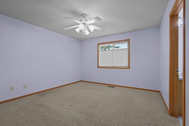 carpeted empty room with ceiling fan and a textured ceiling