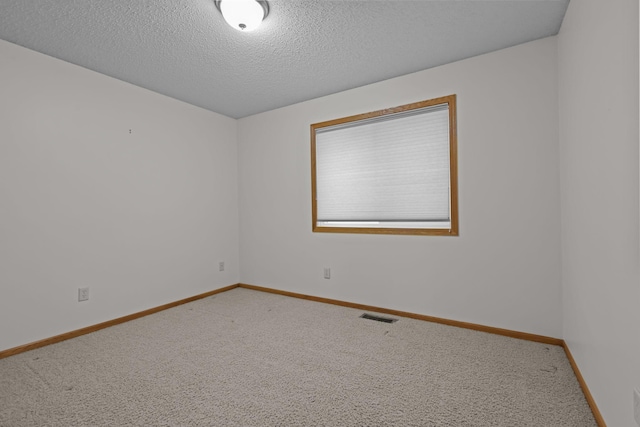 spare room featuring carpet floors and a textured ceiling