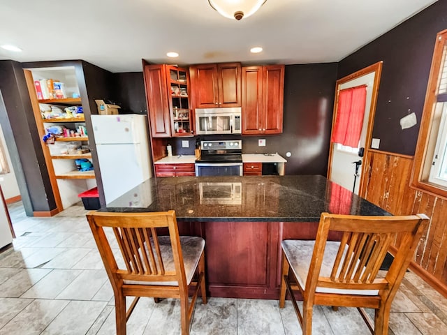 kitchen featuring dark stone countertops, stainless steel appliances, and a breakfast bar