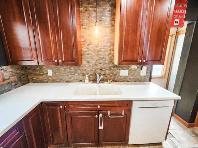 kitchen featuring sink, pendant lighting, white dishwasher, light tile patterned floors, and backsplash