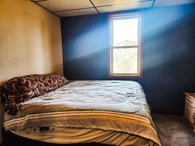 bedroom with a paneled ceiling and carpet