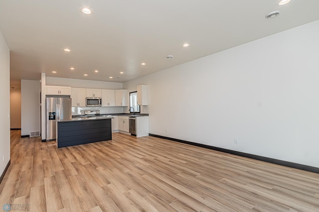 kitchen with a kitchen island, light hardwood / wood-style flooring, sink, stainless steel appliances, and white cabinets