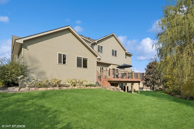 back of property with a deck and a lawn