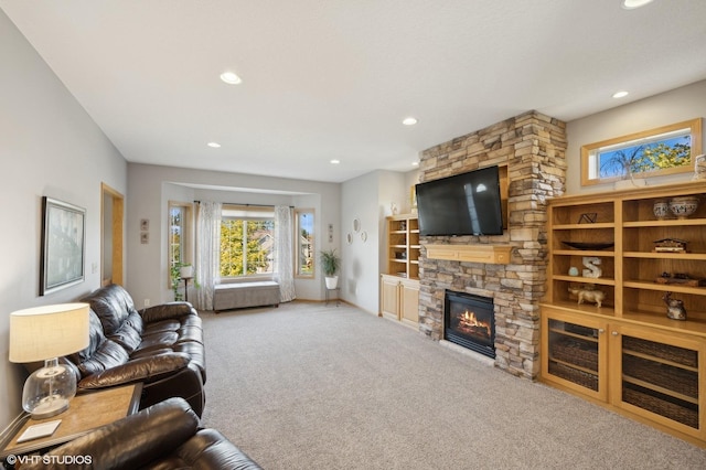 living room with carpet and a stone fireplace