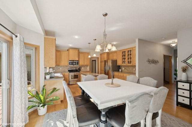 dining space featuring light wood-type flooring and a notable chandelier