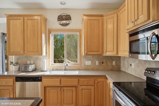 kitchen featuring decorative backsplash, sink, and appliances with stainless steel finishes