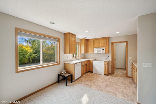 kitchen featuring light carpet, white appliances, and sink