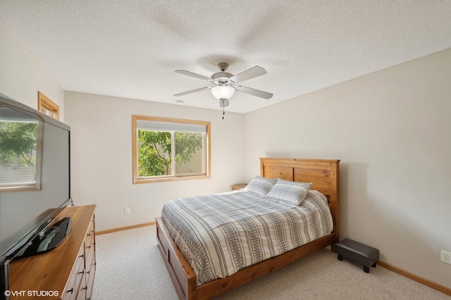 bedroom featuring light carpet, a textured ceiling, and ceiling fan