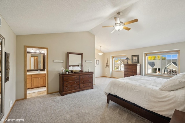 carpeted bedroom featuring a textured ceiling, connected bathroom, ceiling fan, and lofted ceiling