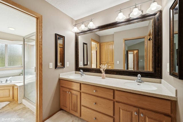 bathroom featuring shower with separate bathtub, vanity, a textured ceiling, and tile patterned floors